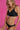 Woman wearing a black soft bra against a pink background